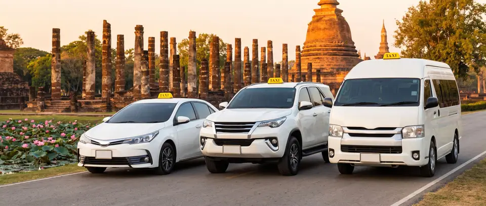 รถเก๋ง SUV และรถตู้แท็กซี่ จอดข้างโบราณสถานในอุทยานประวัติศาสตร์สุโขทัย